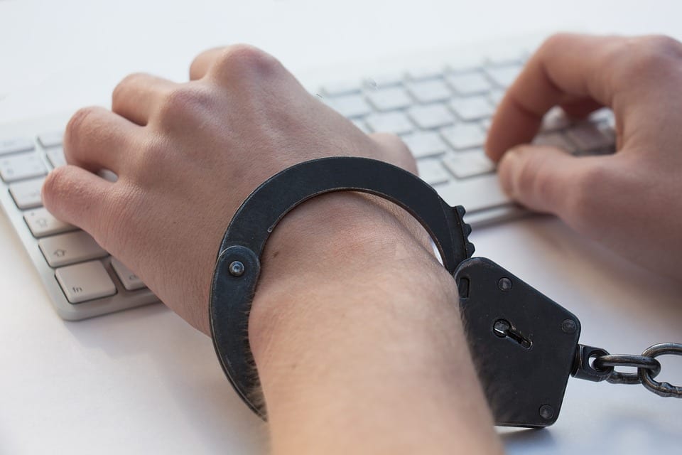 stock photo handcuffed hands on keyboard